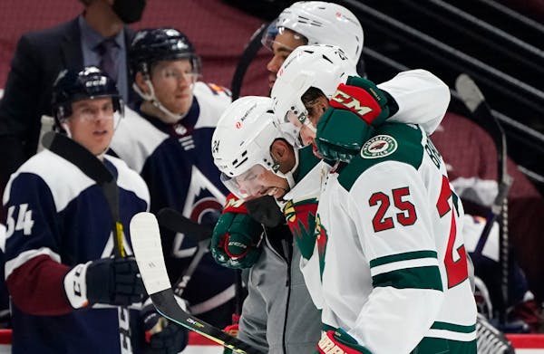 Wild defenseman Matt Dumba, center, is helped off the ice by Jonas Brodin, front, and Jordan Greenway after being injured in the second period