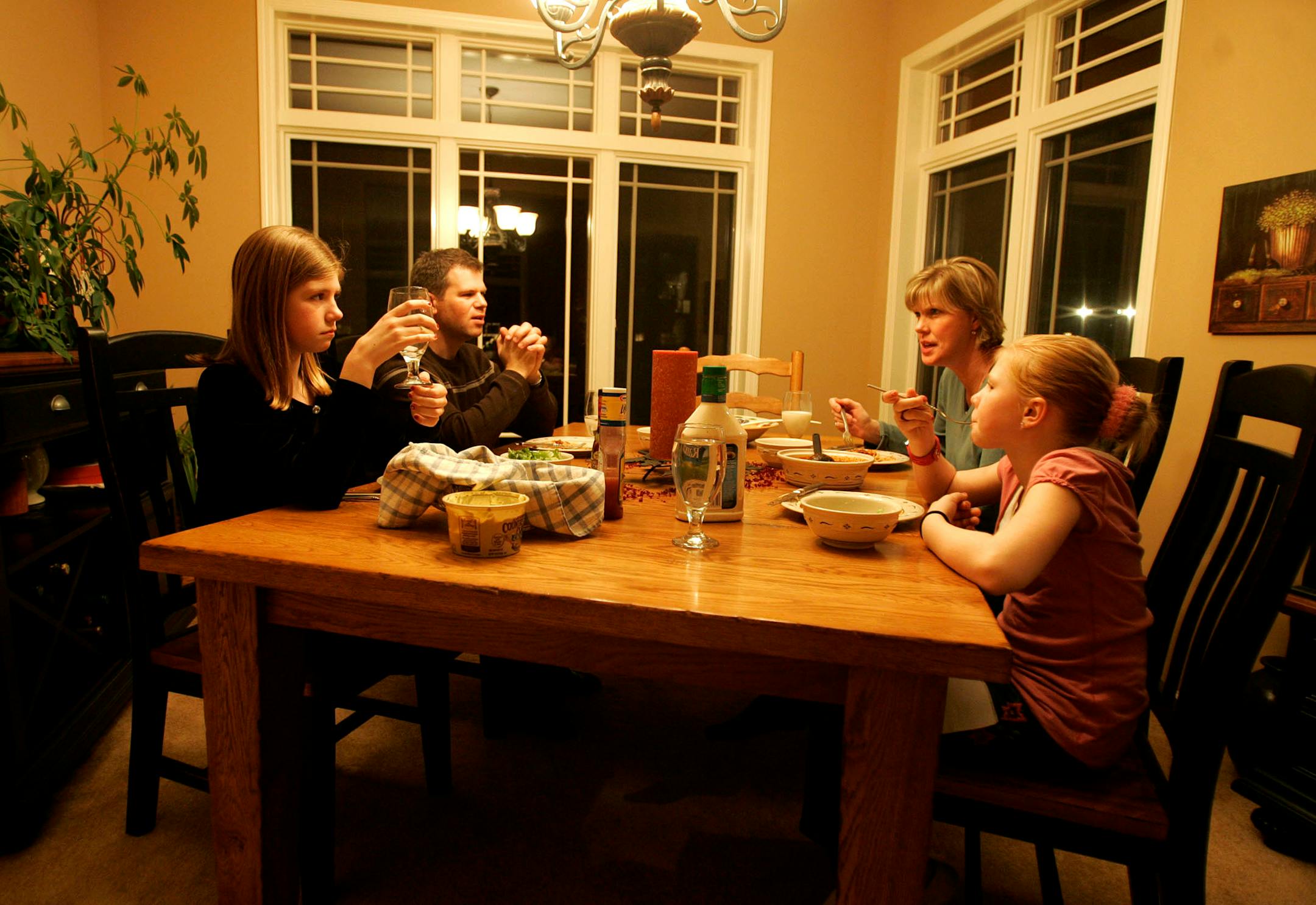 The Berg family, including (from left) Emily, 11, father Chris, mother Beth, and Kate, 8, eat dinner together on most nights. A new study connected such meals with a lower risk of eating disorders.