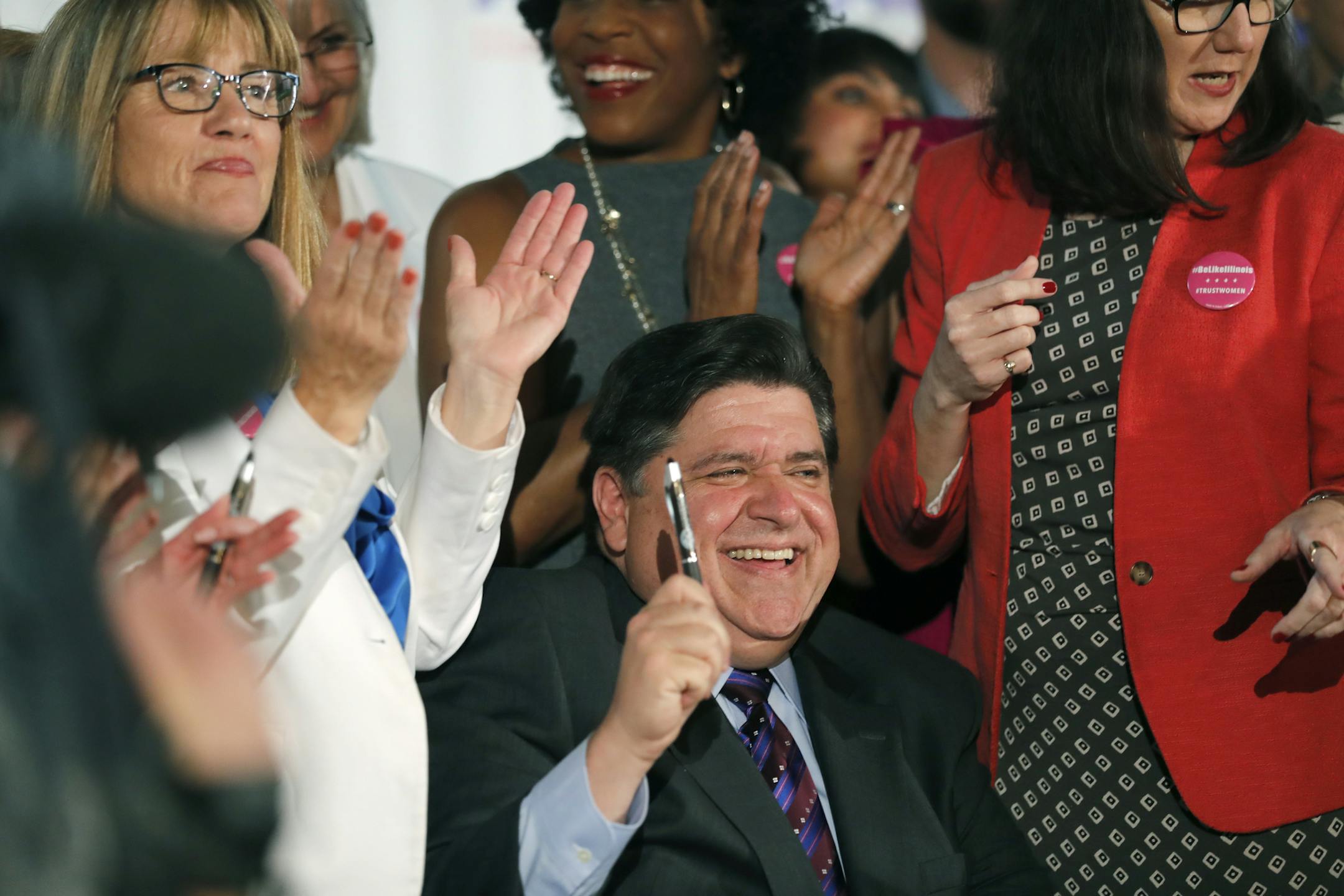 Illinois Gov. J.B. Pritzker signs the Reproductive Health Act into law with bill sponsors Illinois State Senator Melinda Bush, left, and Illinois State Rep. Kelly Cassidy, right, at the Chicago Cultural Center on Wednesday, June 12, 2019. The law establishes "the fundamental right" of a pregnant woman to have an abortion and states that "a fertilized egg, embryo, or fetus does not have independent rights." (Jose M. Osorio/Chicago Tribune via AP)