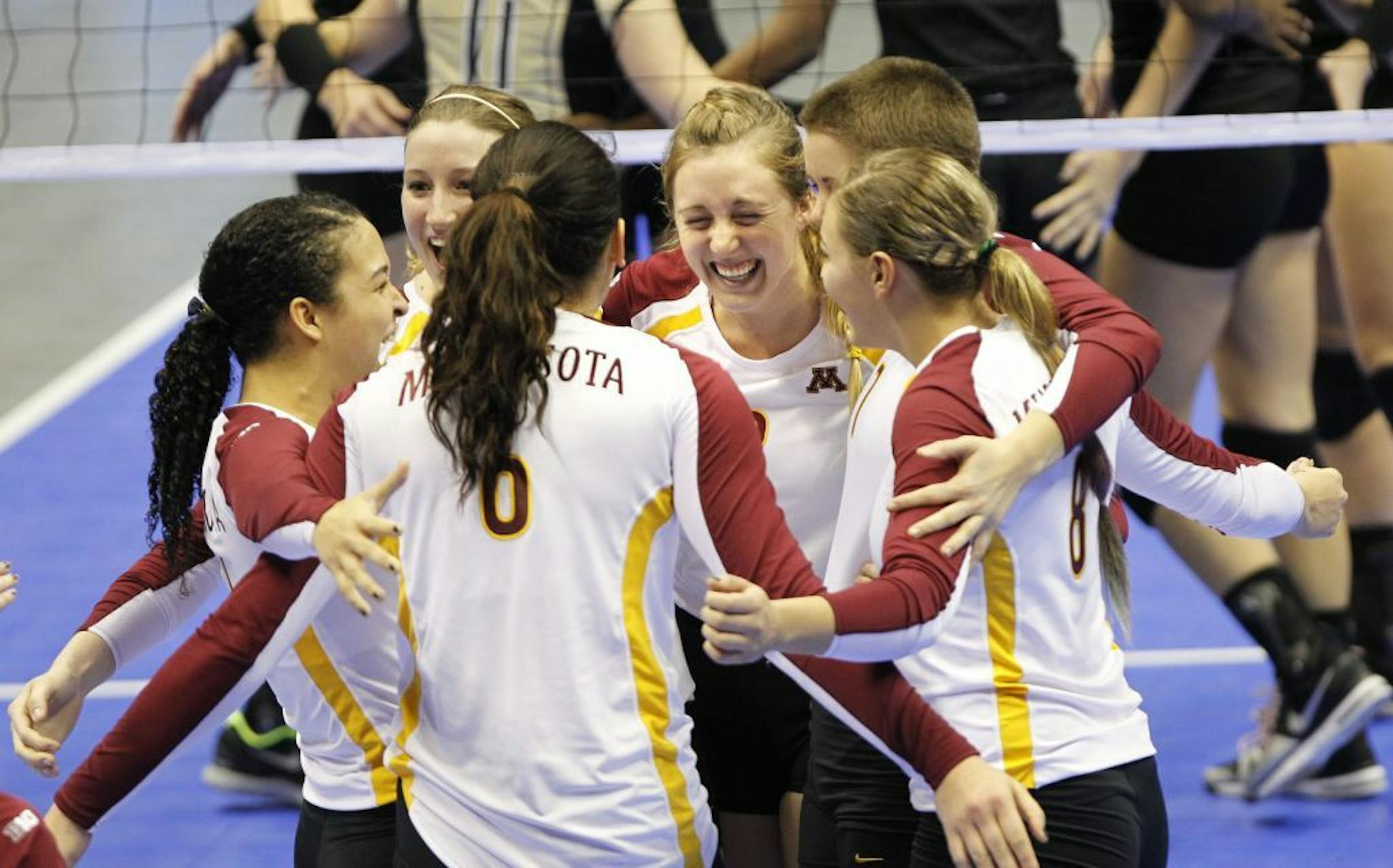 Minnesota players celebrate after defeating Purdue 23-25, 26-24, 25-23, 25-21.