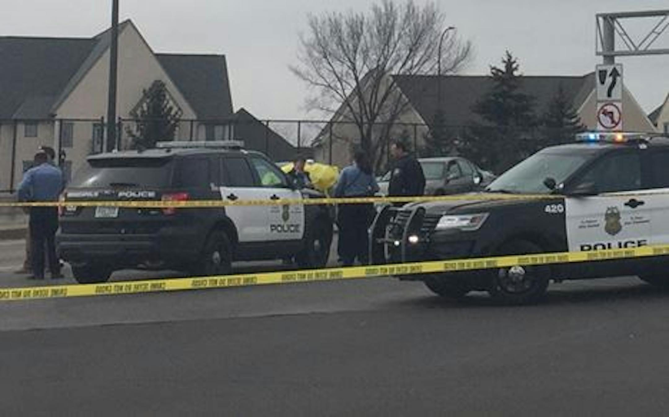 Police vehicles swarmed the scene where a car, with a yellow tarp, was hit with gunfire Sunday afternoon on the edge of downtown Minneapolis.