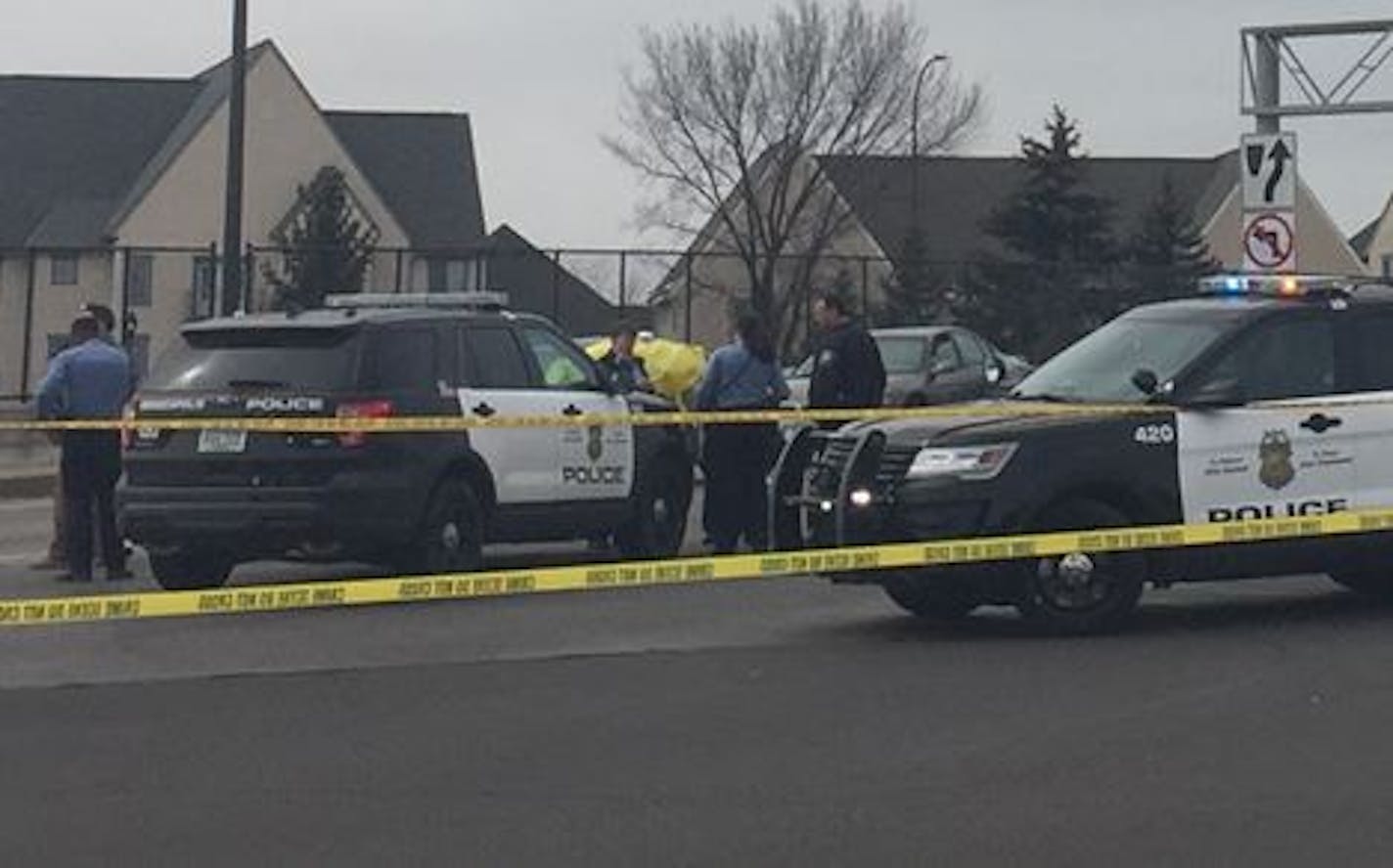 Police vehicles swarmed the scene where a car, with a yellow tarp, was hit with gunfire Sunday afternoon on the edge of downtown Minneapolis.