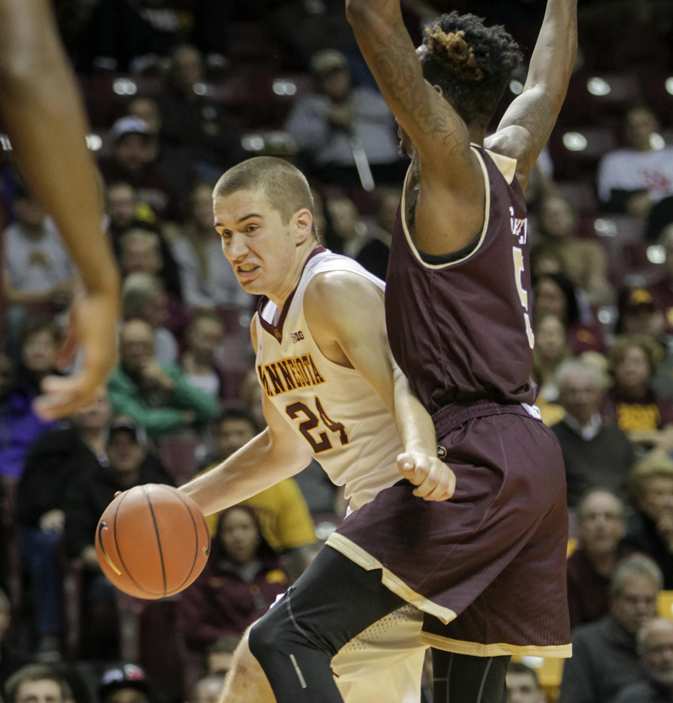 Minnesota forward Joey King (24) drives against Louisiana-Monroe forward Jamaal Samuel (5) during the second half of an NCAA college basketball game, Sunday, Nov. 15, 2015, in Minneapolis. King had a game-high 20 points as Minnesota won 67-56. (AP Photo/Paul Battaglia) ORG XMIT: MIN2015112920220630