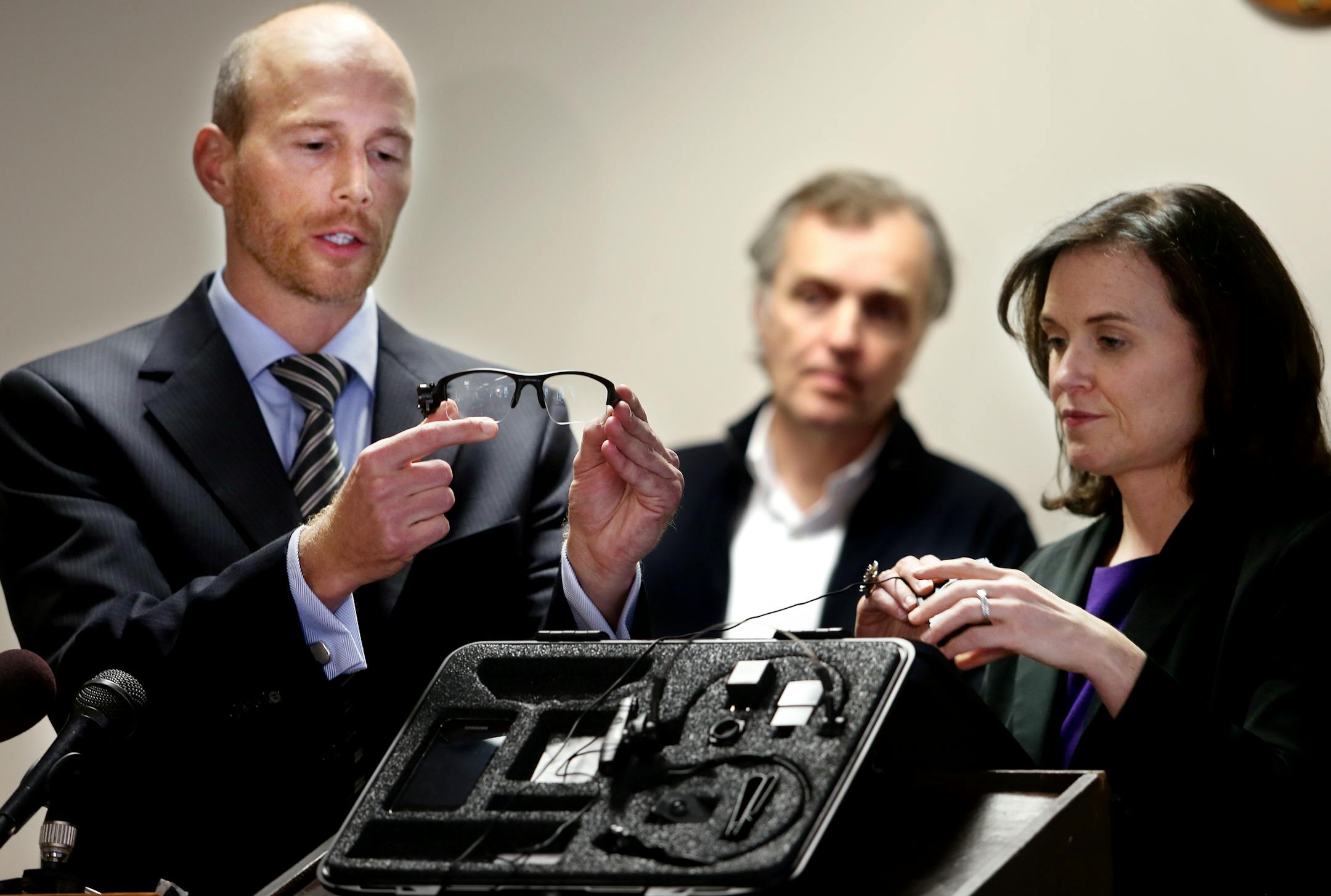 Minneapolis city council members Gary Schiff and Betsy Hodges show off the body camera system they say will be used by Minneapolis police as part of a pilot program. Council member Cam Gordon is in the background during the event in Minneapolis on Oct. 17, 2013.