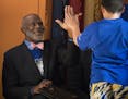 Justice Alan Page high fives students after the rhino hula hoop toss contest.