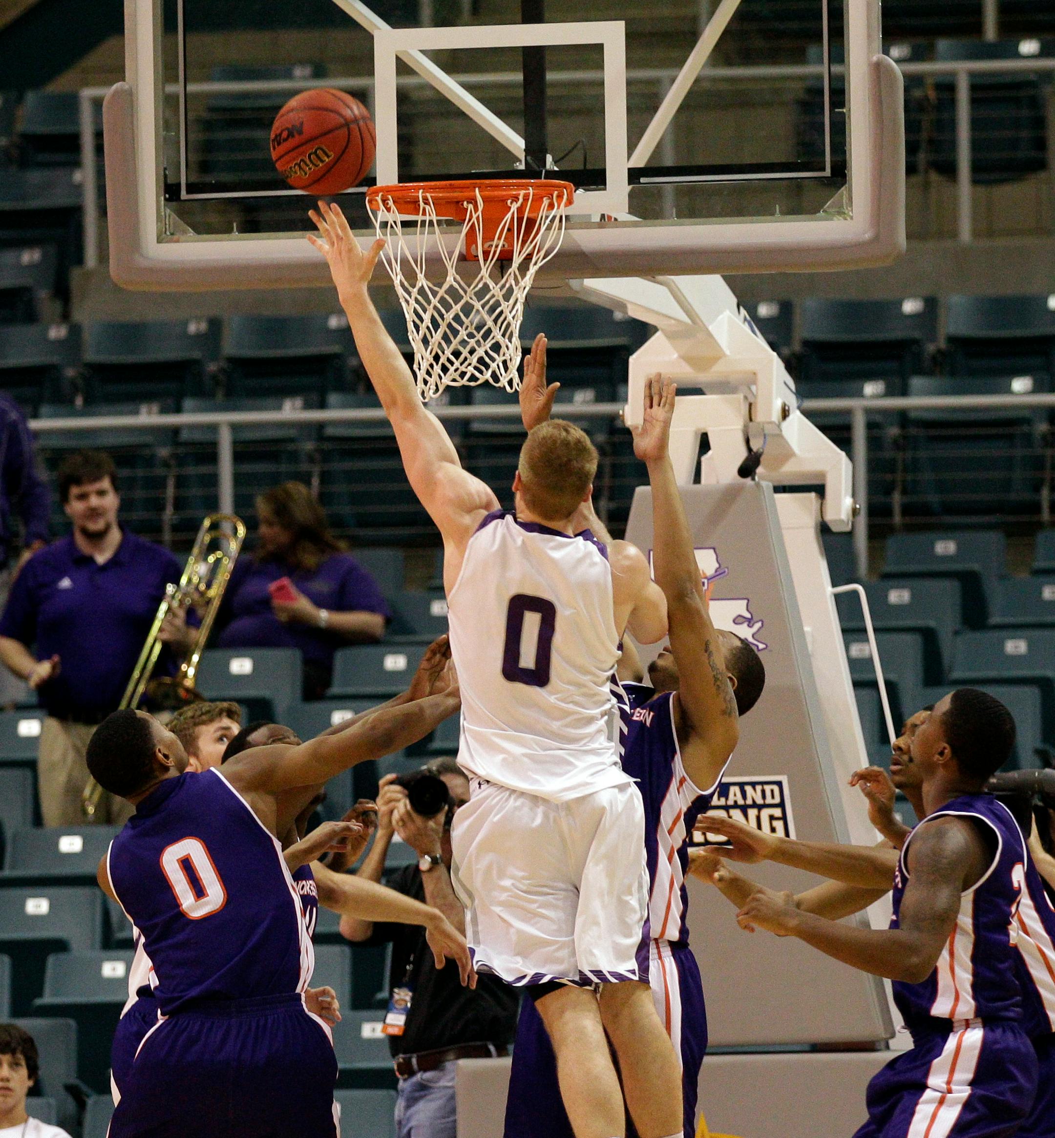 Stephen F. Austin's Thomas Walkup (0) puts back an offensive rebound for a layup over Northwestern State's Tra'von Joseph (0) during the first half of an NCAA college basketball game in the semifinal round of the Southland Conference tournament Friday, March 14, 2014, in Katy. (AP Photo/Bob Levey)