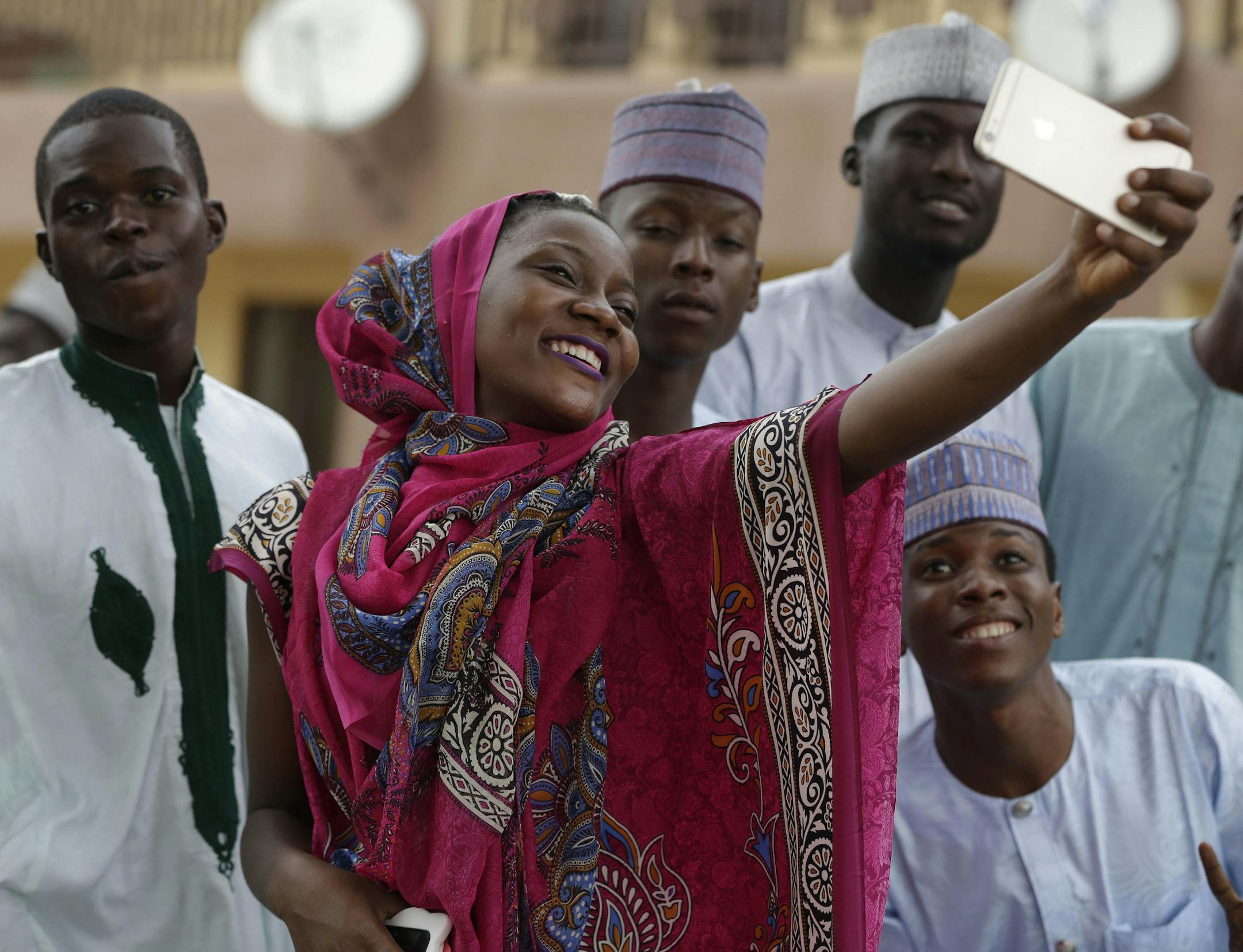 A Muslim woman and friends take a selfie photo after Eid al-Adha, the "Feast of Sacrifice" that commemorates the Prophet Ibrahim's faith, in Lagos, Nigeria, on Monday, Sept. 12, 2016. Eid al-Adha marks the end of hajj. (AP Photo/Sunday Alamba)