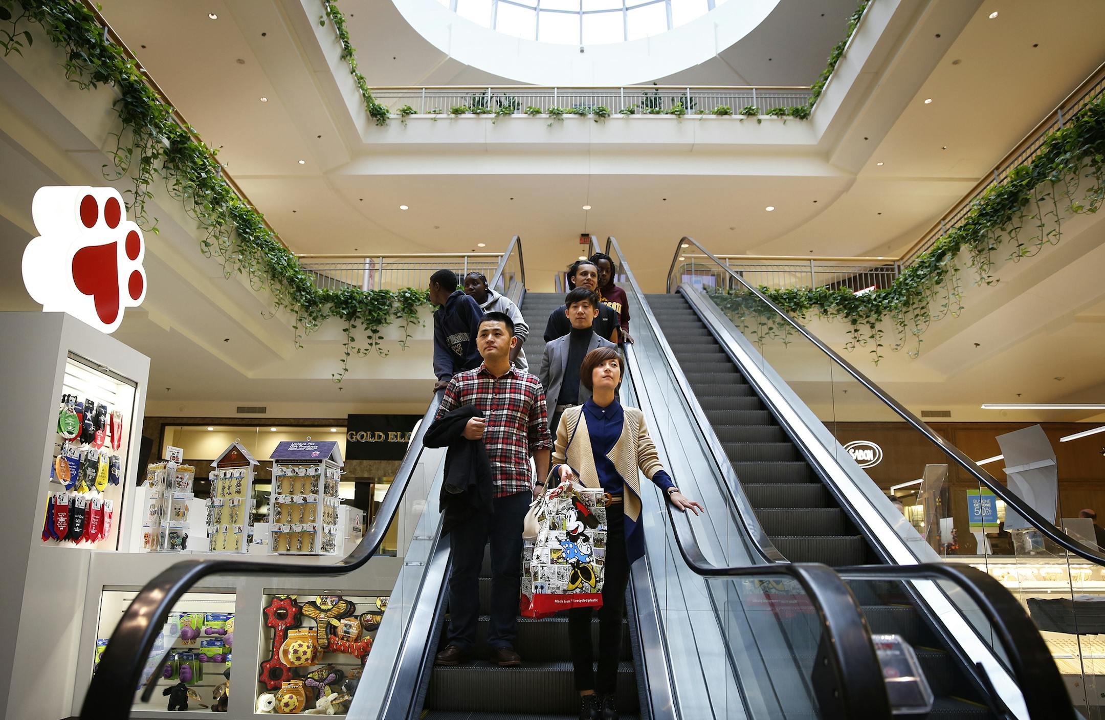 Lu Yan, clockwise from bottom right, and Yao Tao Tao, both from China and in town for a trade show, shop at Mall of America in Bloomington with their guide Ming Jia of CIAC Travel. ] LEILA NAVIDI leila.navidi@startribune.com / BACKGROUND INFORMATION: Monday, October 13, 2014. The Mall of America is honing in on China as a key market for attracting new shoppers in the next decade. It has hired a marketing firm in China to plug the mall as a tourist destination and is encouraging its stores to acc