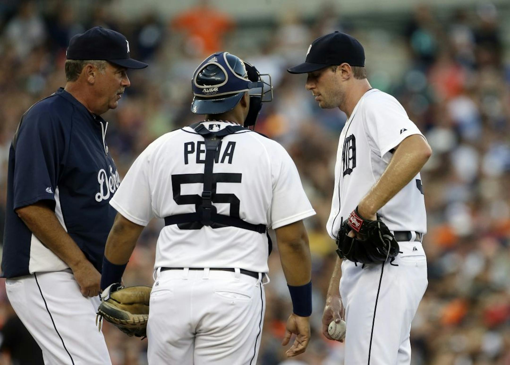Detroit Tigers pitching coach coach Jeff Jones, left, walks to the mound for a chat with pitcher Max Scherzer and catcher Brayan Pena during the fourth inning of a baseball game against the Texas Rangers in Detroit, Saturday, July 13, 2013.