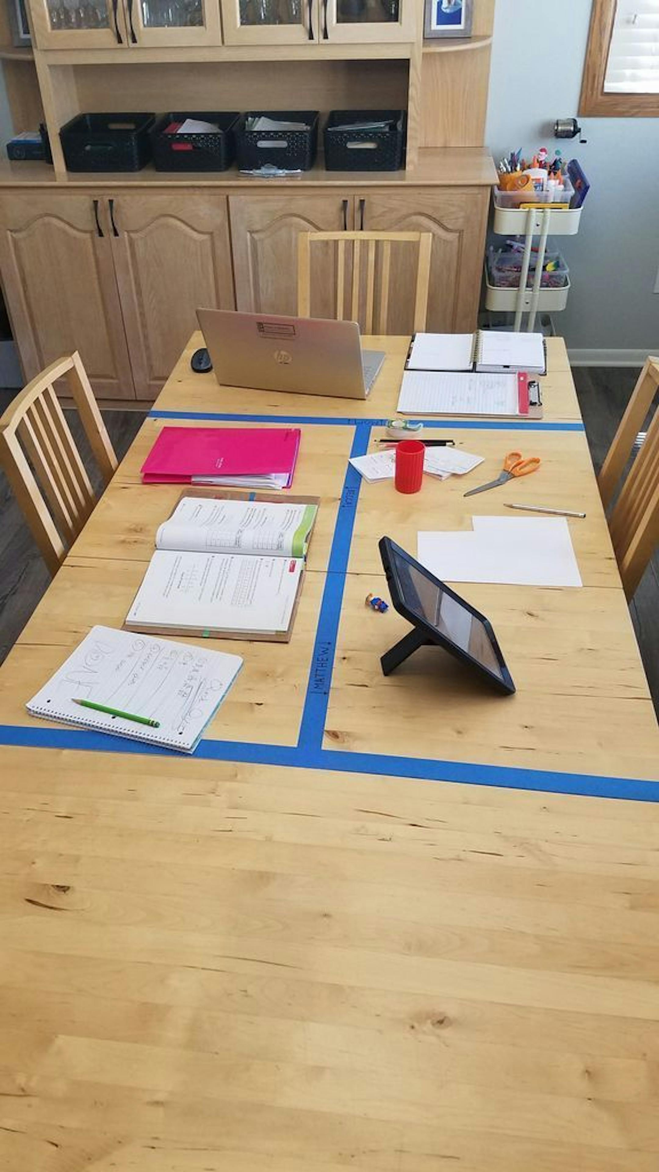 Masking tape delineates work stations for family members at a dining table in professional organizer Sarah Cronin's home. She owns Simply Inspired Home Organizing.