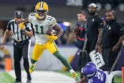 Green Bay Packers wide receiver Jayden Reed (11) picked up 6 yard in the first quarter as Minnesota Vikings cornerback Akayleb Evans (21) forced him o