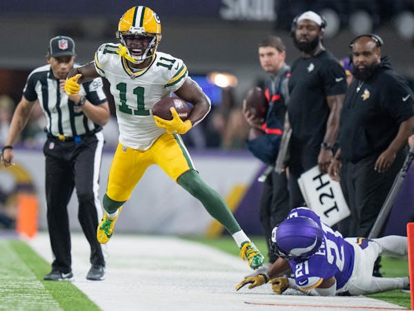 Green Bay Packers wide receiver Jayden Reed (11) picked up 6 yard in the first quarter as Minnesota Vikings cornerback Akayleb Evans (21) forced him o