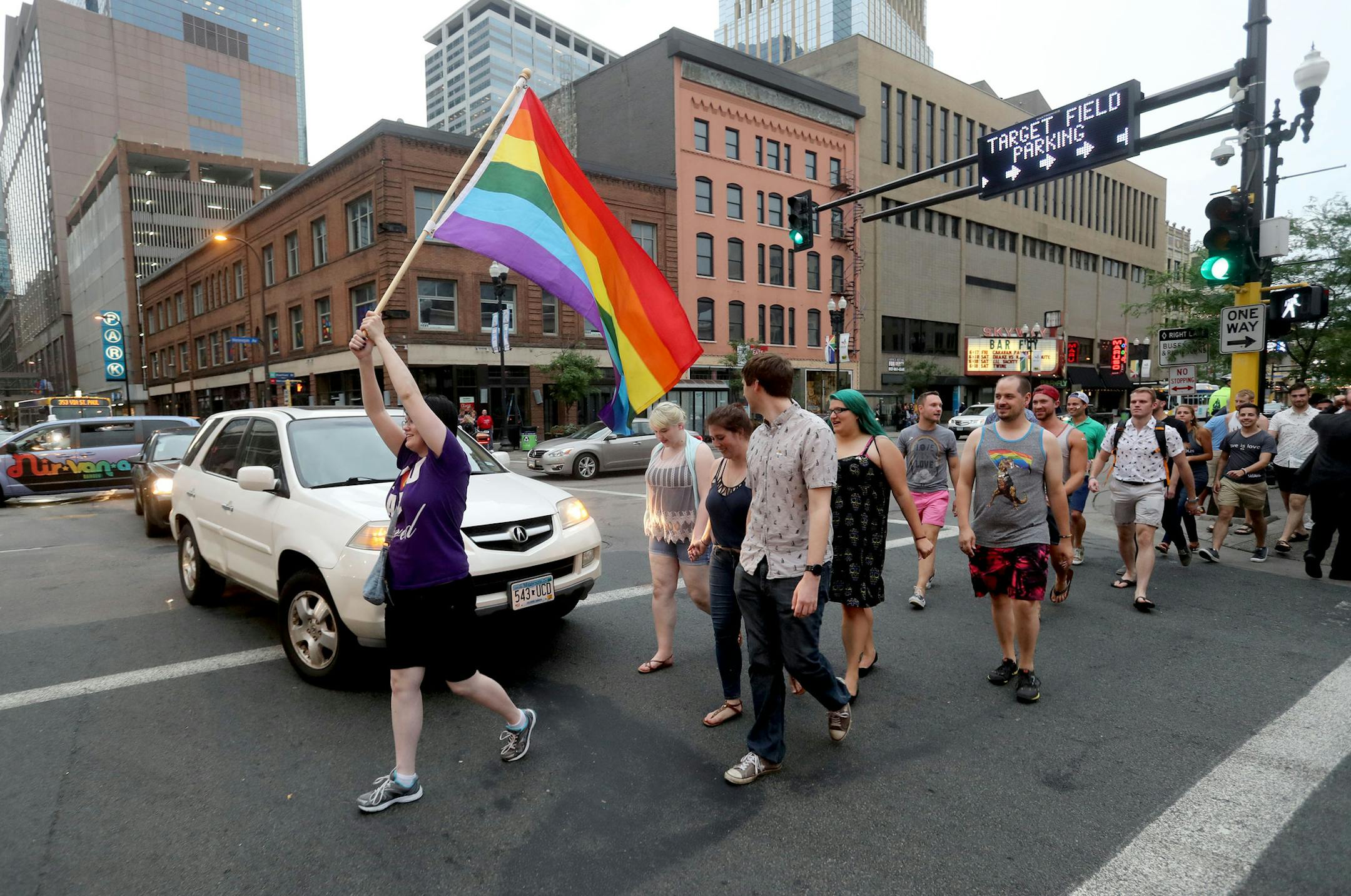 Participants in the Emergency Minneapolis Queer Bar Crawl head down Hennepin Avenue from the Saloon to the Gay 90s in order to raise money for the victims of the Orlando attack at Pulse Nightclub Friday, June 17, 2016, in Minneapolis, MN. Here, Sarah Mauser of W. St. Paul carried the Pride flag along the route.](DAVID JOLES/STARTRIBUNE)djoles@startribune Event called Minneapolis Emergency Queer Bar Crawl: Gay bars in Minneapolis are holding a pub crawl on Friday night, with drink proceeds benefi