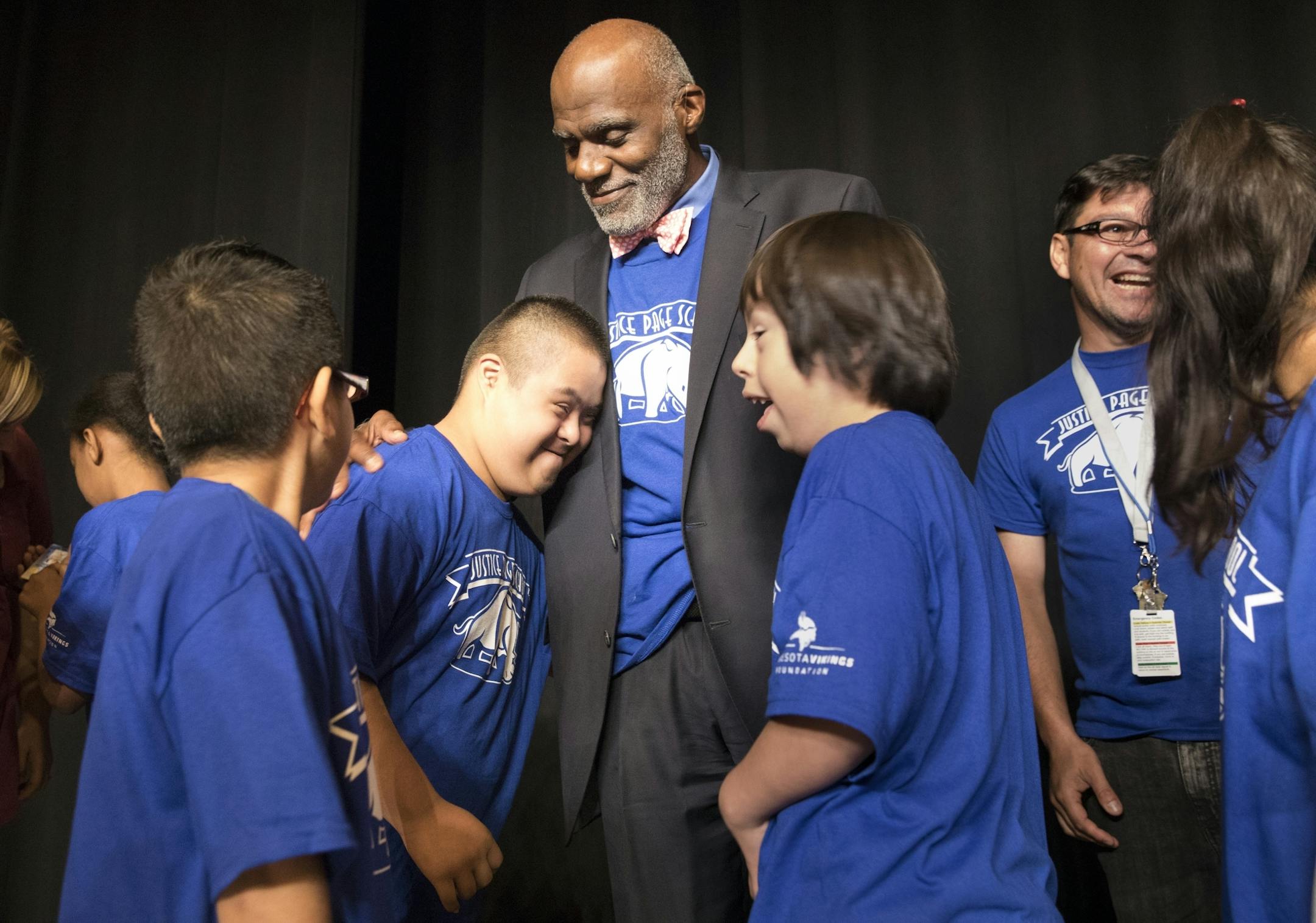 Alan Page gets a hug from eighth-grader Daniel Gallegos after the assembly Friday the Minneapolis middle school now named for the former Vikings star and Minnesota Supreme Court justice.