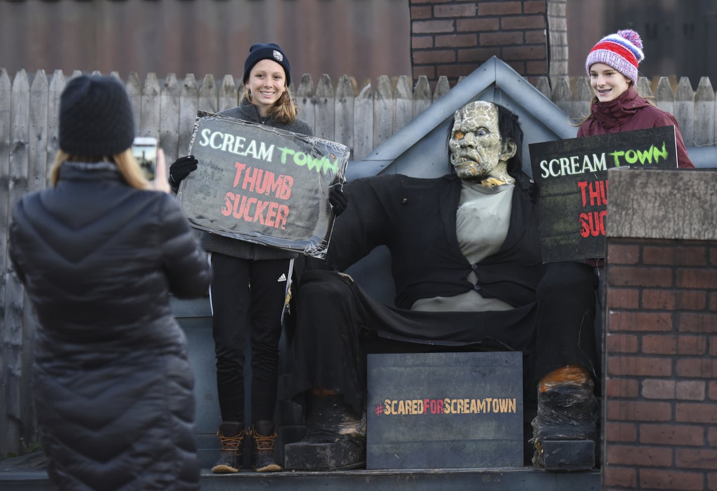 Anika Olson, right, and Molly Westin, both 13, posed for photos for Molly's mother, Kris Westin, of Chaska, as they entered Scream Town Friday night.