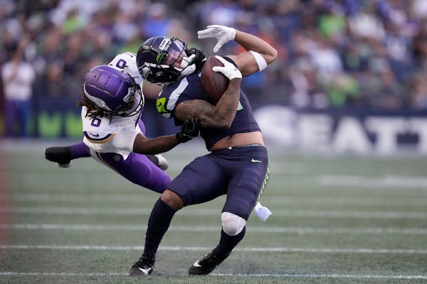 Vikings safety Lewis Cine, left, tackled Seattle wide receiver Jaxon Smith-Njigba during the teams’ preseason opener Thursday night.