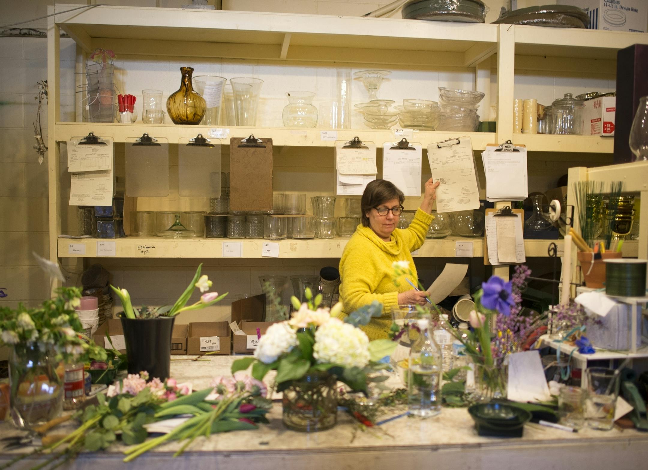 Fleur de Lis Flowers owner Robin Rivard grabbed a clipboard with order and delivery information for a client Friday afternoon while working on Valentines Day orders.