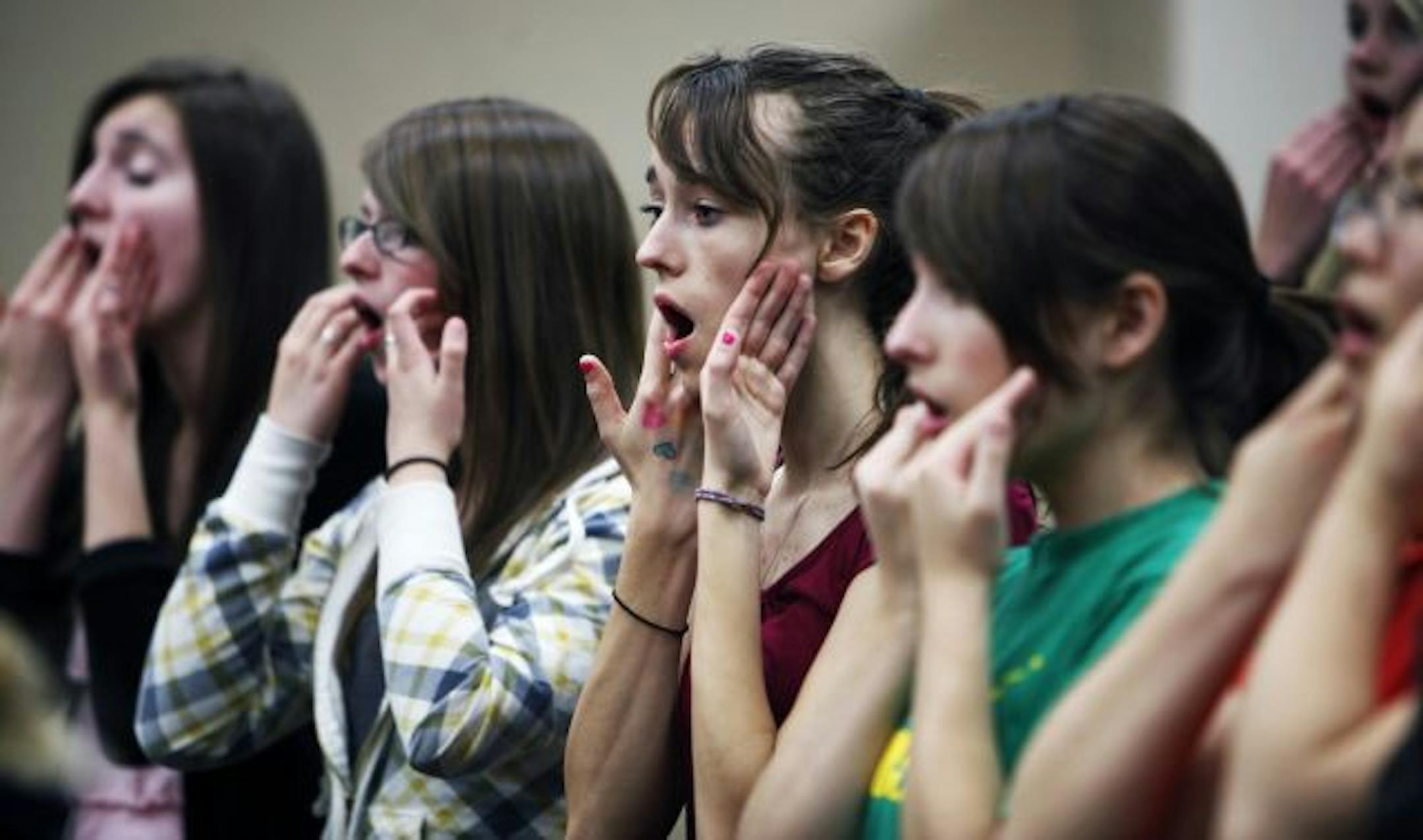 During rehearsal for Chamber Choir, Rachel Amundsen, center right, and other girls in grades 9-12 warmed up their vocal chords.