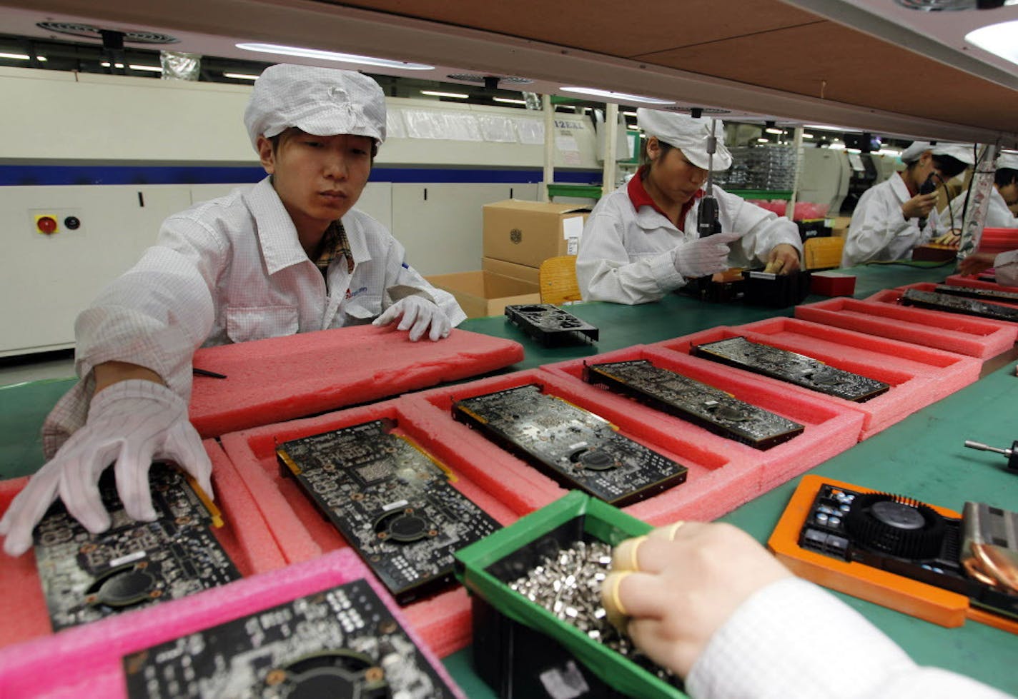 FILE - In this May 26, 2010 file photo, staff members work on the production line at the Foxconn complex in the southern Chinese city of Shenzhen. China's economy surged 10.3 percent in 2010, spurred by a torrent of investment in property and other areas that also fanned politically volatile inflation. Figures released Thursday Jan. 20, 2011, by the National Statistics Bureau showed inflation moderating in December from a 28-month high in November as food prices eased, but analysts warned that w