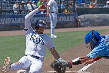 Brandon Lowe, a hot hitter lately for Tampa Bay, slides safely past Ali Sanchez of the Toronto Blue Jays on Sunday at George M. Steinbrenner Field.