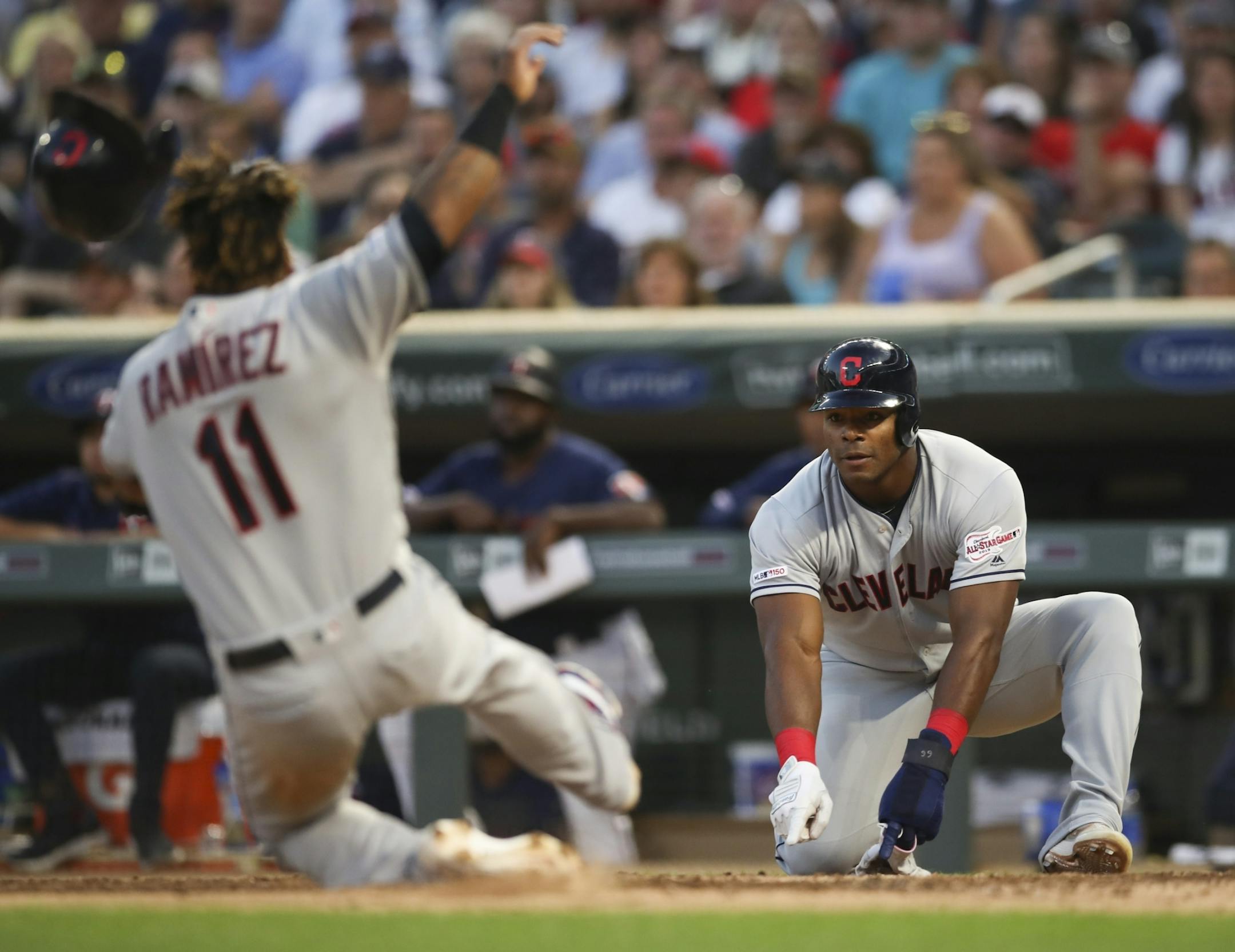 Cleveland Indians right fielder Yasiel Puig indicated for teammate Cleveland Indians third baseman Jose Ramierez (11) to slide when they both scored on Cleveland Indians second baseman Jason Kipnis double in the fourth inning.