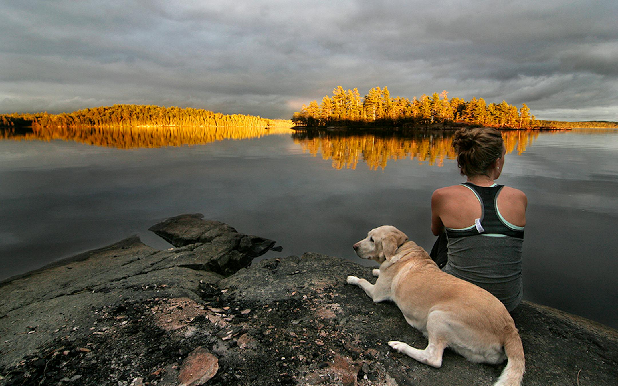 Megan Smith and her yellow Lab, Macy, enjoy a spectacular sunset on a BWCA.