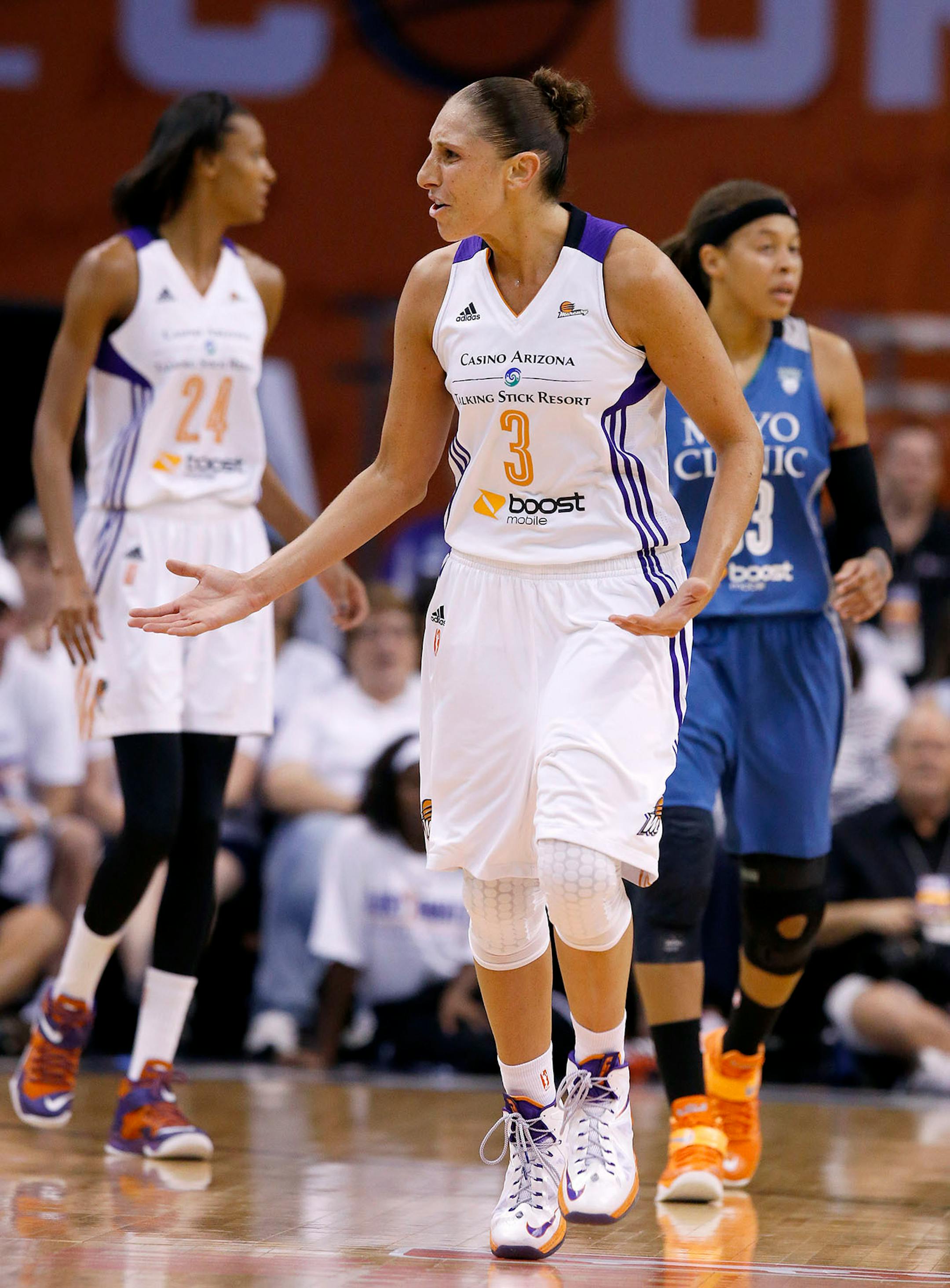 Phoenix Mercury's Diana Taurasi (3) argues with a referee over a dribble carry call against her as Mercury's DeWanna Bonner (24) and Minnesota Lynx's Seimone Augustus, right, look for the ball during the first half in Game 1 of the WNBA Western Conference Finals Friday, Aug. 29, 2014, in Phoenix. (AP Photo/Ross D. Franklin)