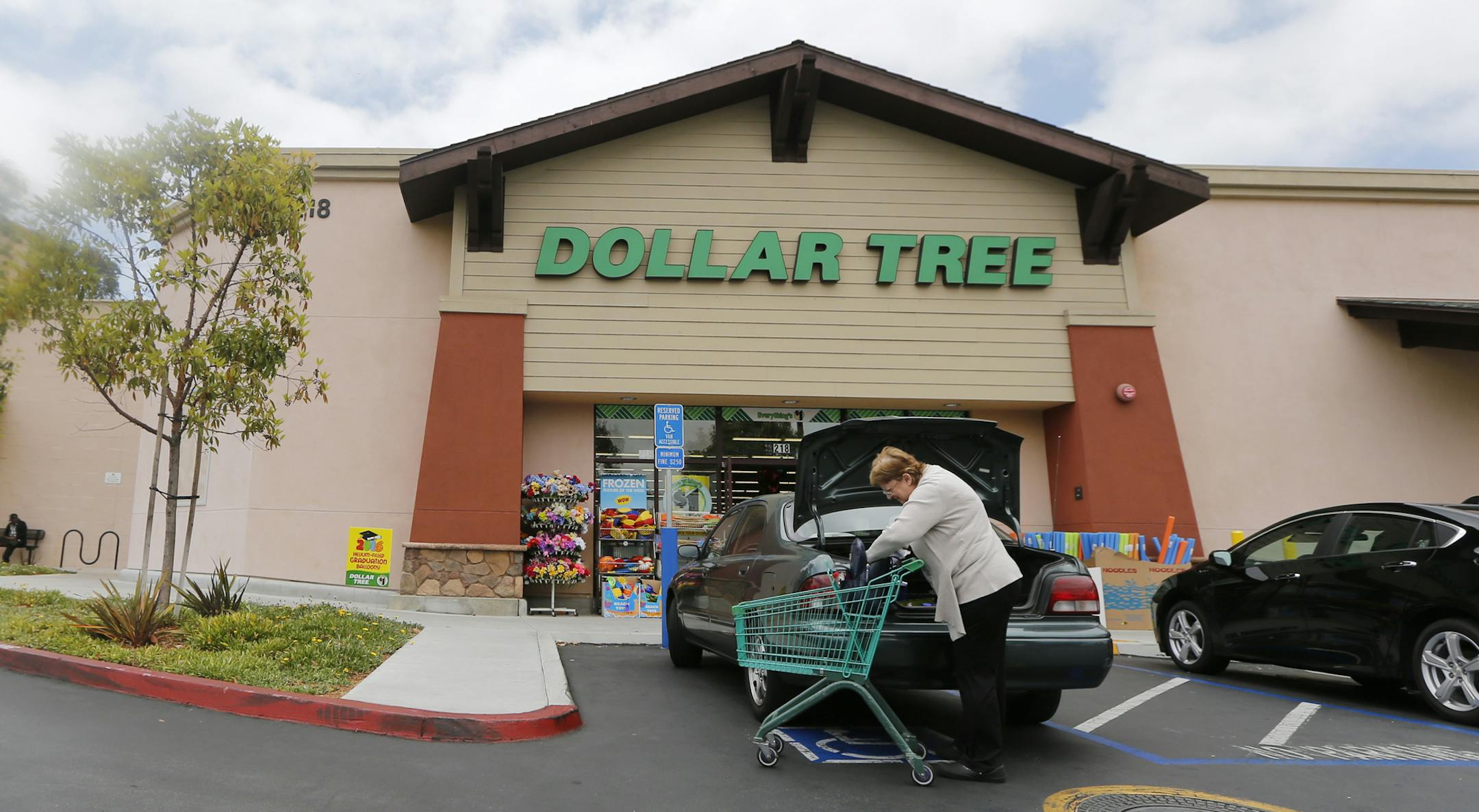 In this Thursday, May 26, 2016, photo, a shopper searches her purse outside a Dollar Tree store in Encinitas, Calif. Dollar Tree, Inc. reports earnings Tuesday, Nov. 22, 2016. (AP Photo/Lenny Ignelzi)