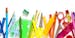 Large group of rainbow colored school supplies coming from the top and bottom of the frame shot from above against white background leaving a useful c