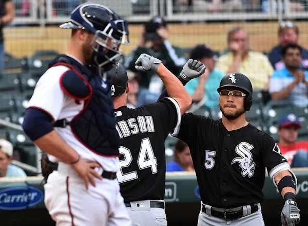 Chicago White Sox's Matt Davidson is congratulated by Yolmer Sanchez after hitting a solo home run against the Minnesota Twins during the ninth inning