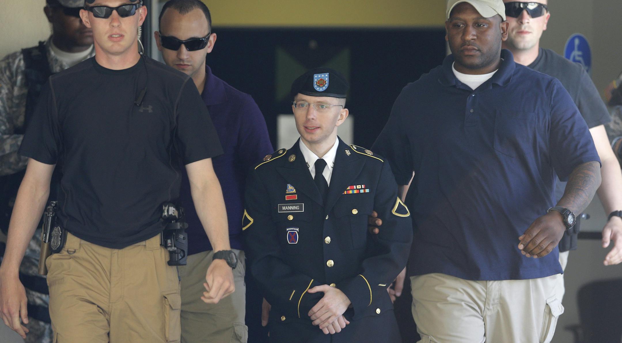 Army Pfc. Bradley Manning, center, is escorted out of a courthouse in Fort Meade, Md., in June, 2013.