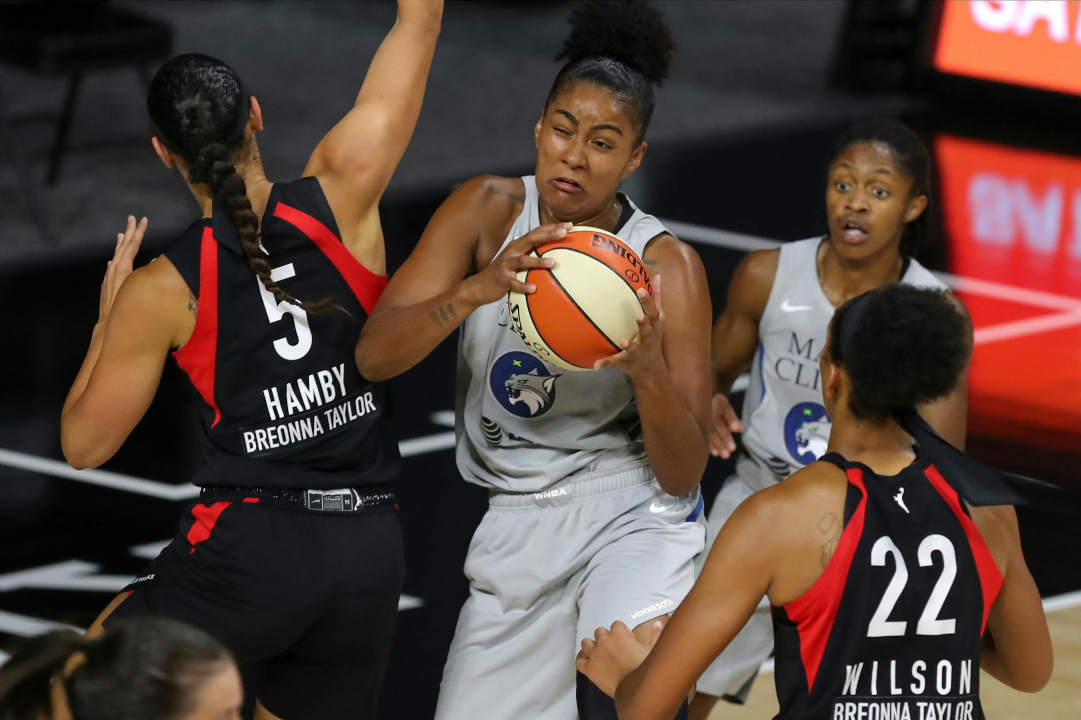 The Lynx's Damiris Dantas, center, grabs a rebound between Las Vegas Aces' Dearica Hamby (5) and A'ja Wilson (22) during the first half