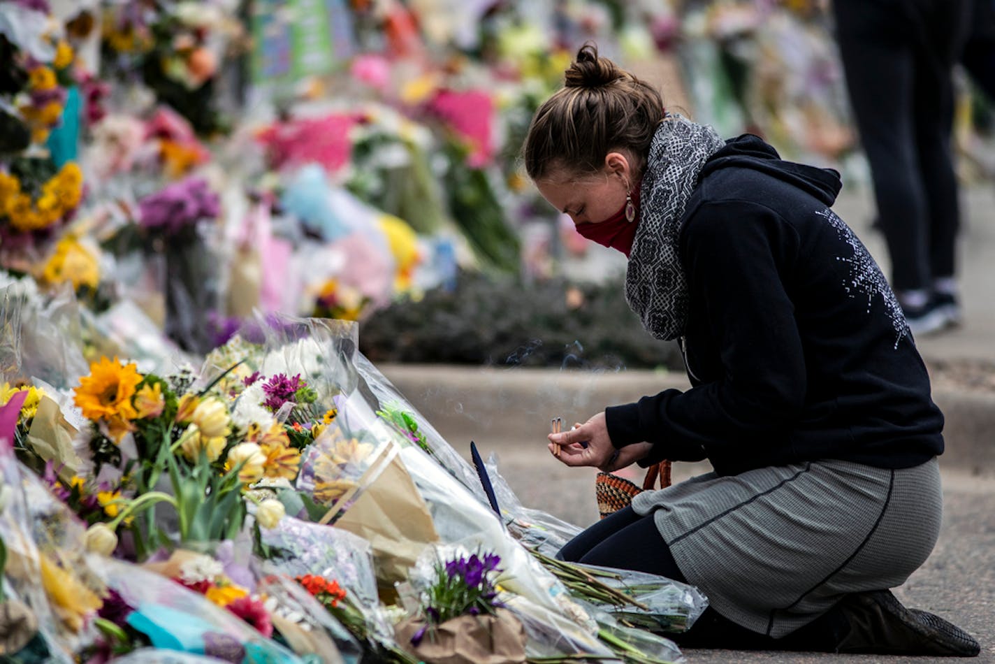 A woman burns incense at a memorial for shooting victims at a King Soopers Grocery store on March 26, 2021, in Boulder, Colorado. A stabilizing brace was used by the shooter, who killed 10. (Chet Strange/Getty Images/TNS) ORG XMIT: 18431071W