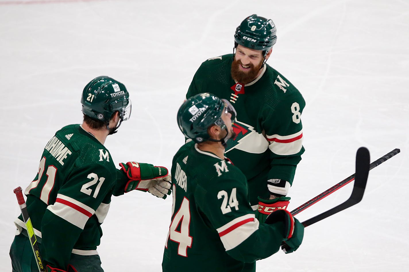 Minnesota Wild defenseman Jordie Benn (8) celebrates his goal with teammates Brandon Duhaime (21) and Matt Dumba (24) in the second period of an NHL hockey game against the Montreal Canadiens, Monday, Jan. 24, 2022, in St. Paul, Minn. (AP Photo/Andy Clayton-King)