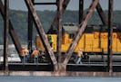 Railroad workers congregate on the Hoffman Swing Bridge after a Union Pacific train derailed on the bridge and a fuel car spilled 3,500 gallons of die