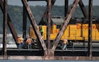 Railroad workers congregate on the Hoffman Swing Bridge after a Union Pacific train derailed on the bridge and a fuel car spilled 3,500 gallons of die