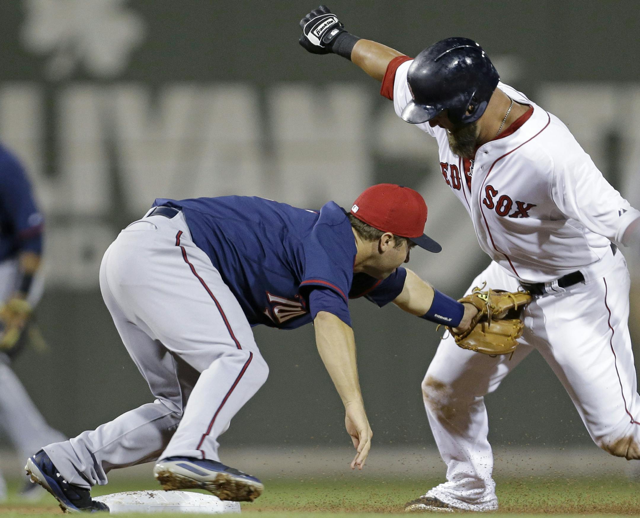 Boston Red Sox Mike Napoli, right, is tagged out at second by Minnesota Twins second baseman Brian Dozier while trying to stretch his hit into a double in the fourth inning of an exhibition baseball game in Fort Myers, Fla., Thursday, March 27, 2014. (AP Photo/Gerald Herbert)