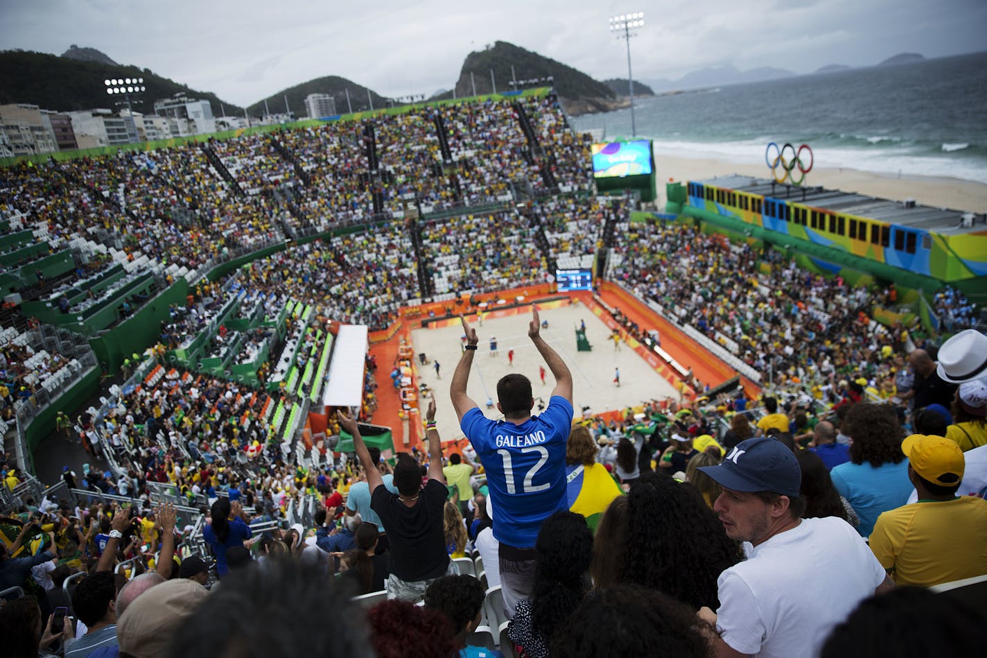 A fan cheers for Brazil as the play against Austria in a men's beach volleyball match at the 2016 Summer Olympics in Rio de Janeiro, Brazil, Monday, Aug. 8, 2016. (AP Photo/David Goldman)