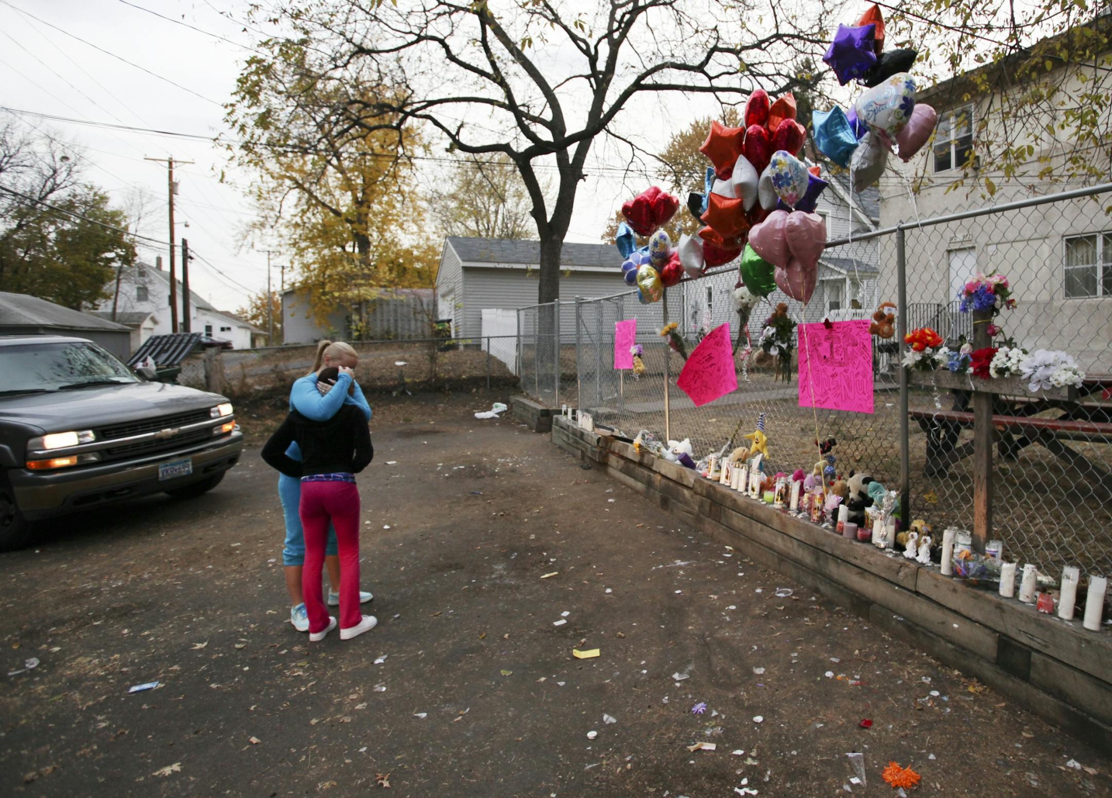 A memorial site set up near where Naressa Turner was killed appears to have been vandalized overnight, shortly after a vigil for Turner was held in the alley behind 970 Reaney Ave. in St. Paul. Here, two people pay their respects.
