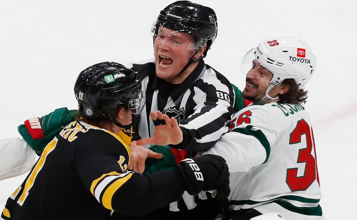 Linesman Jonathan Deschamps tries to separate Boston's Trent Frederic and the Wild's Mats Zuccarello during the first period