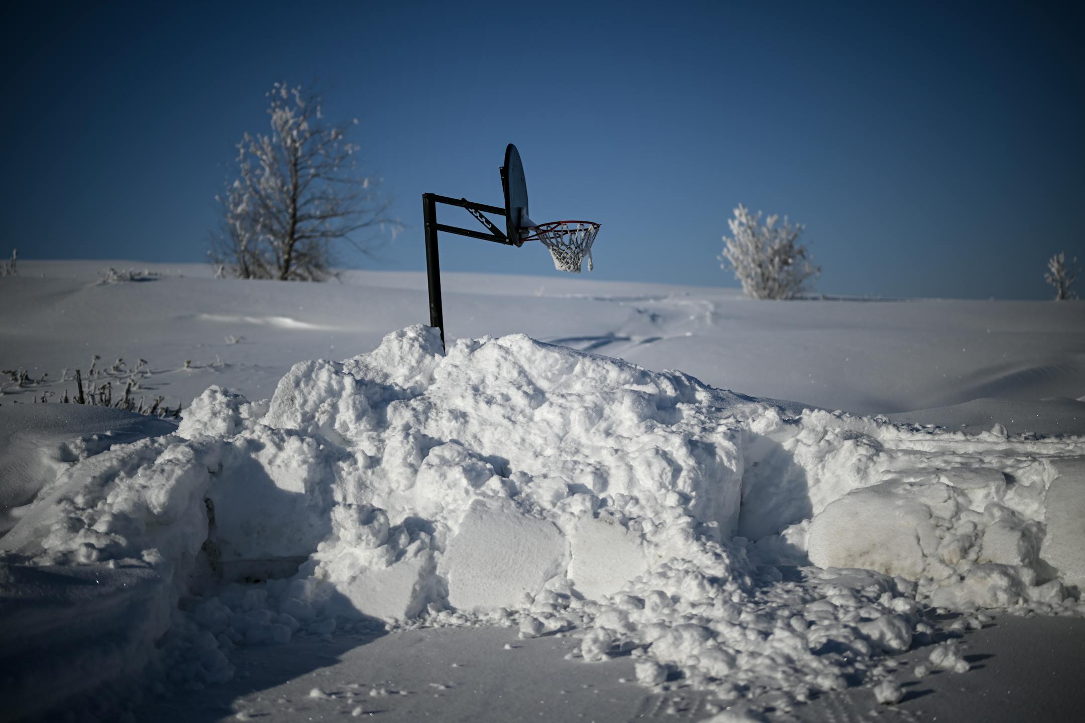 A snowed-in basketball hoop at the end of a Londsdale neighborhood road.