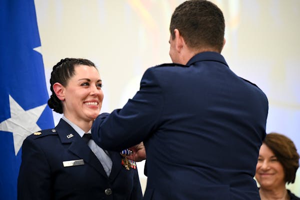Air Force Major Katie Lunning of the Minnesota National Guard's 133rd Airlift Wing is presented with the Distinguished Flying Cross by Lt. General Mic