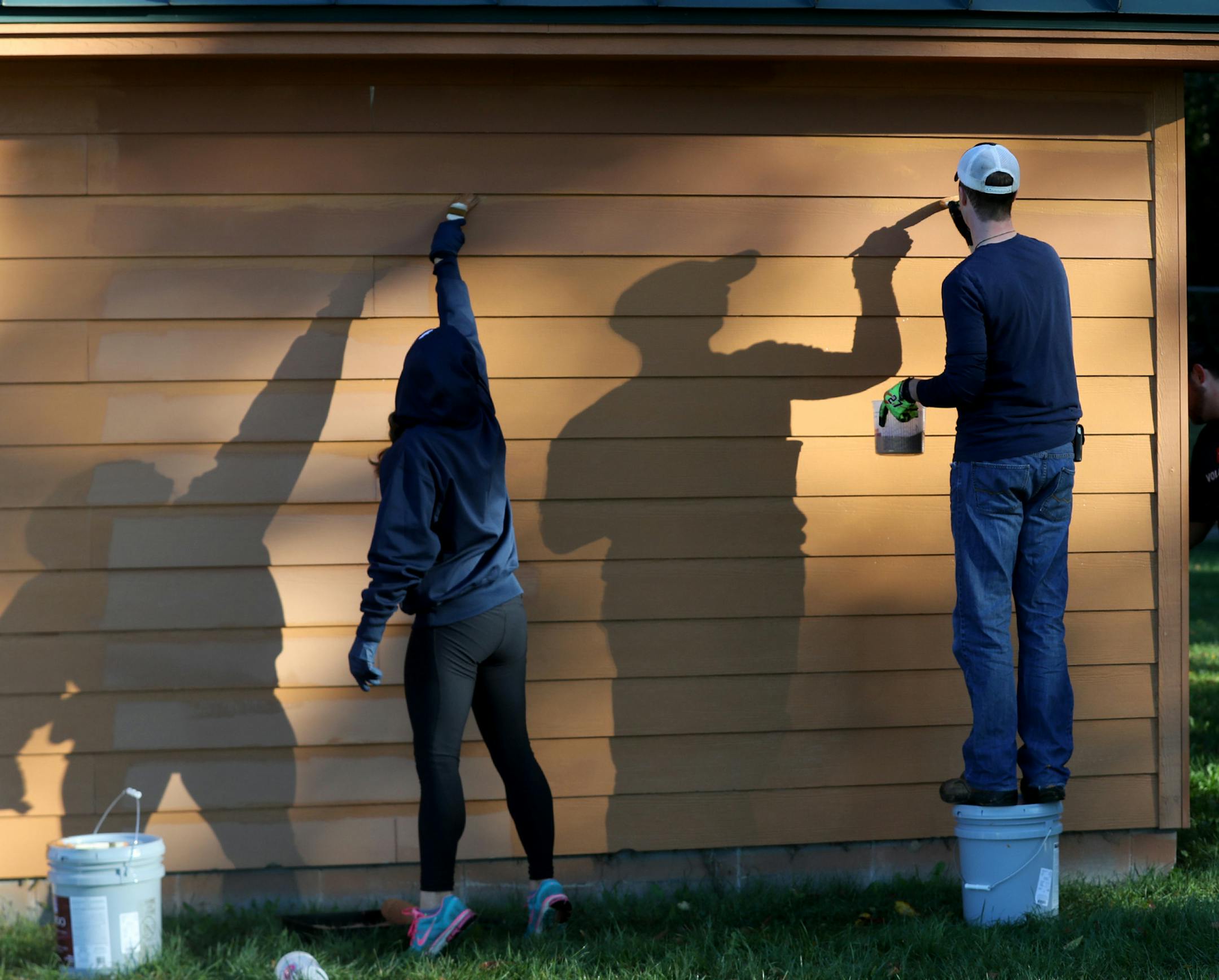 About 60 volunteers from Toro, the Minnesota Twins and the City of Burnsville worked repairing bullpens, rebuilding pitchers' mounds, adding new sod, painting dugouts and more on three ball fields at Dakota Park Wednesday, Oct. 4, 2017, in St. Louis Park, MN. Here, volunteers and also husband and wife, Mike and Brittany Kennedy, right o left, both of whom work for the Minnesota Twins, cast shadows while working to paint an equipment garage.] DAVID JOLES ï david.joles@startribune.com The Tor