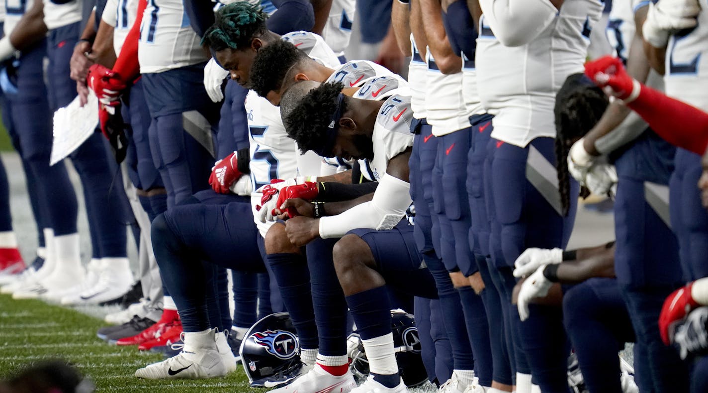 Members of the Tennessee Titans stand and kneel during the national anthem prior to an NFL football game against the Denver Broncos, Monday, Sept. 14, 2020, in Denver. (AP Photo/David Zalubowski)