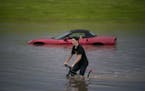 Austin Schiff pedaled past stranded vehicles next to Lakeville North High School in June. The Twin Cities reached its second-highest rainfall this sum