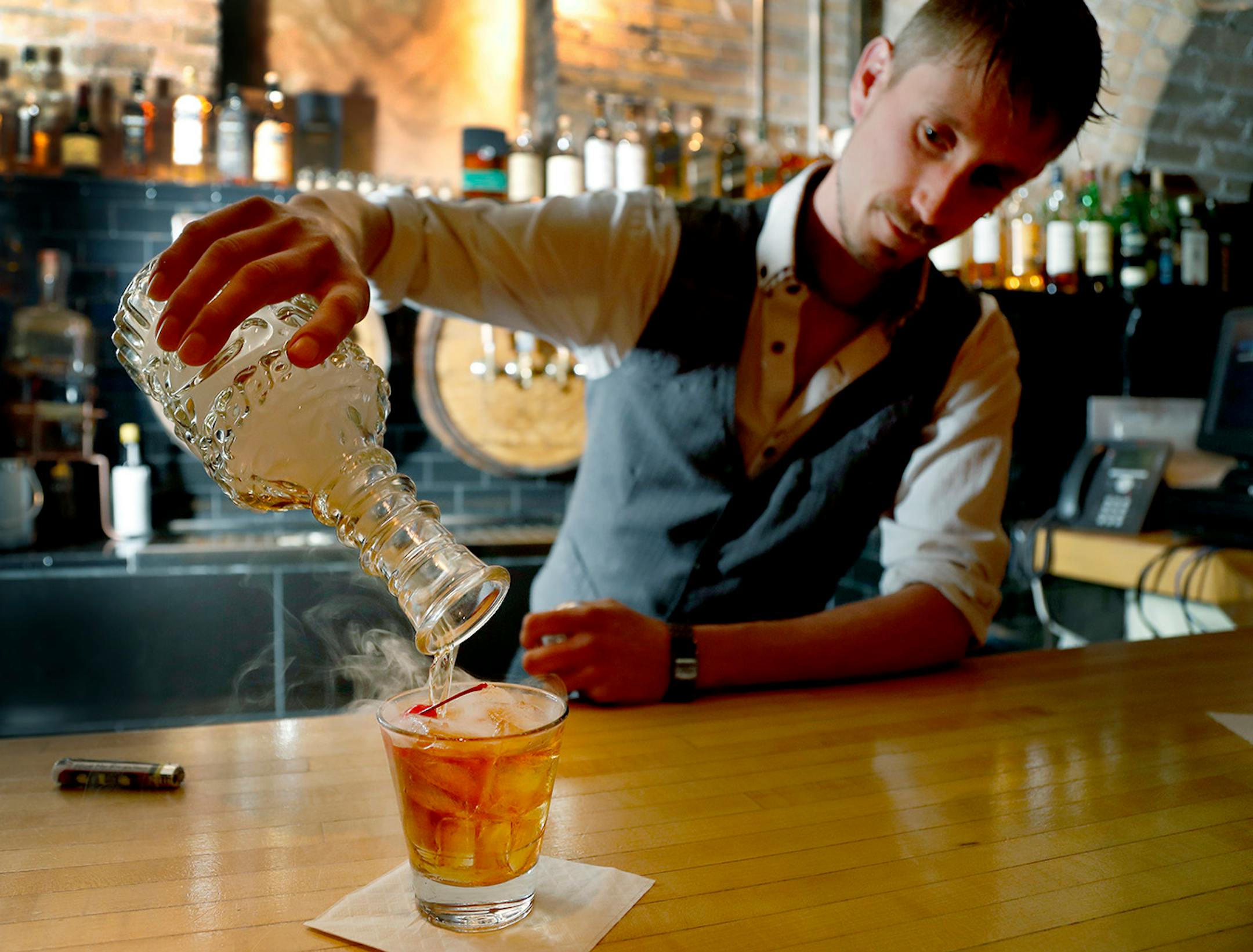 Bartender Cade Grover poured his own creation the "Smoked Caramel Manhattan" at Rathskeller, a speakeasy in Duluth. The specialty drink is not on the menu but can be made by request.