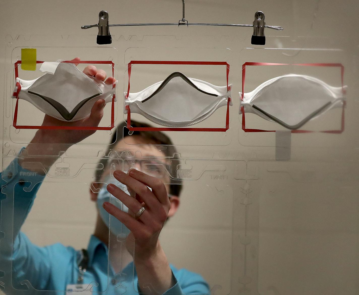 Dan Cates, an infection prevention practitioner at Regions Hospital, demonstrated how used 3M N95 masks will be places onto plastic racks to be sterilized via ultraviolet light.