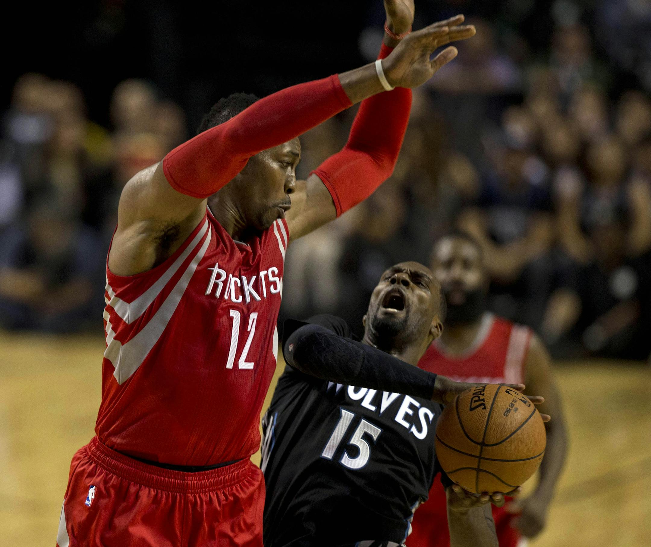 Minnesota Timberwolves' Shabazz Muhammad (15) is fouled by Houston Rockets' Dwight Johnson (12) during the first half of an NBA basketball game in Mexico City, Wednesday, Nov. 12, 2014. (AP Photo/Dario Lopez-Mills)
