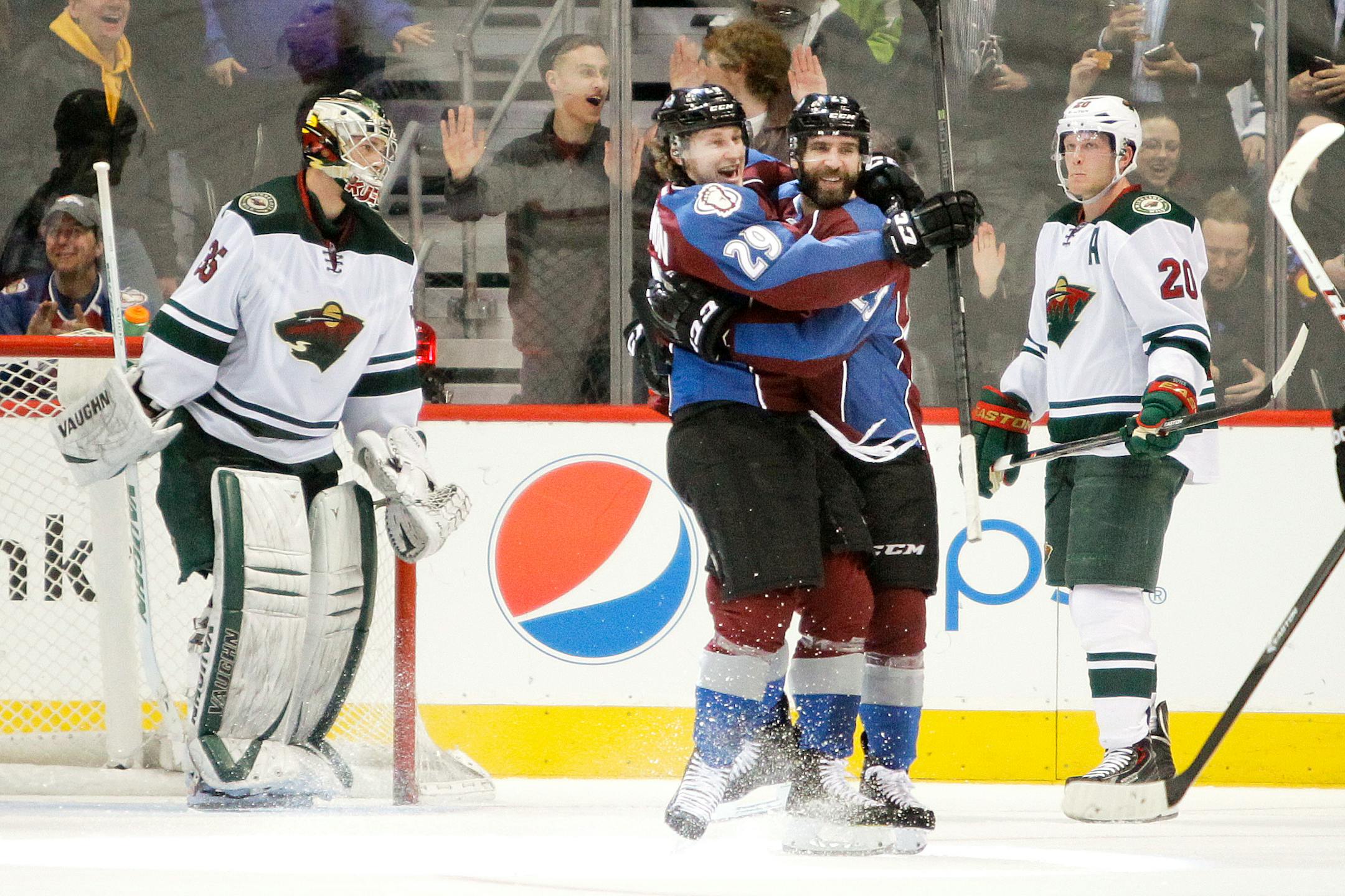 Colorado Avalanche's Nathan MacKinnon (29), second from left, hugs Maxime Talbot, third from left,after he scored during the second period of an NHL hockey game on Thursday, Jan. 30, 2014 in Denver. Minnesota Wild goalie Darcy Kuemper, left, and Ryan Suter, right, react in the background. (AP Photo/Barry Gutierrez)