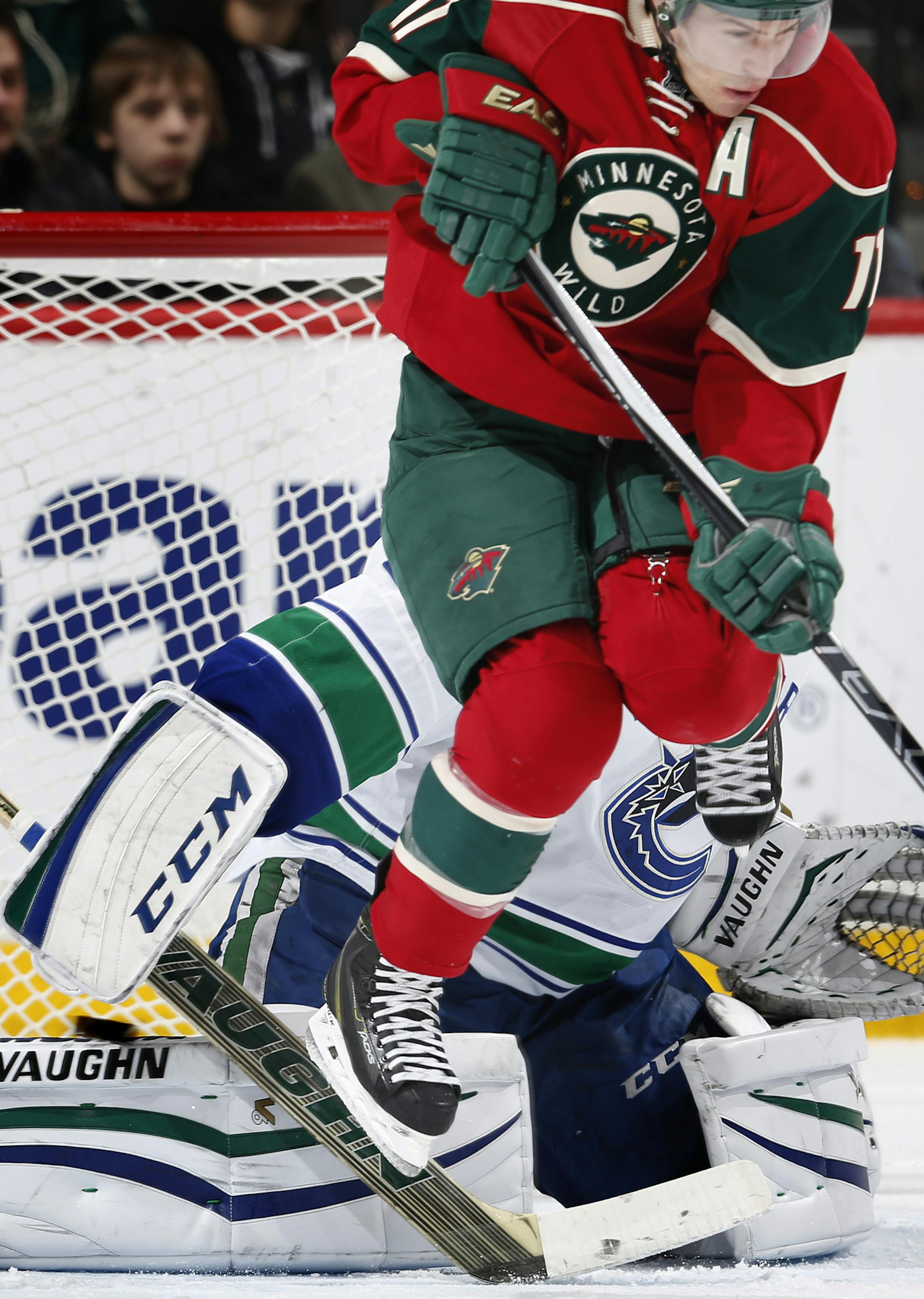 Zach Parise (11) hopped out of the way of a puck shot by Ryan Suter. The shot got past Vancouver Canucks goalie Ryan Miller (30) for a Suter goal in the second period. ] CARLOS GONZALEZ cgonzalez@startribune.com, February 9, 2015, St. Paul, Minn., Xcel Energy Center, NHL, Minnesota Wild vs. Vancouver Canucks
